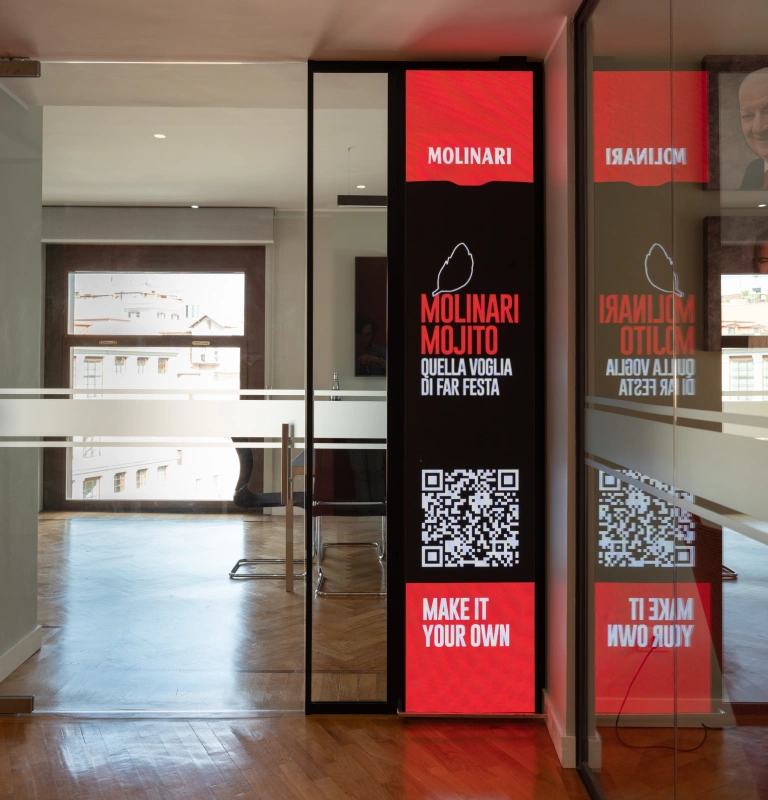 Molinari - Roma. Un allestimento fisico e digitale porta storia, identità e immaginario Molinari all’interno dei nuovi uffici direzionali di Roma.