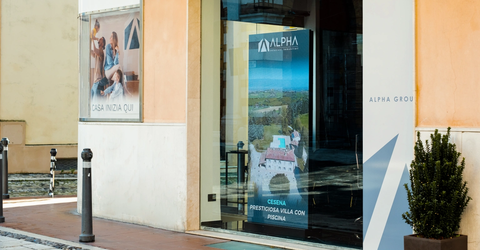 Alpha Immobiliari - Cesena (FC). Un LEDwall ad alta luminosità trasforma la vetrina dell’agenzia in uno spazio di comunicazione digitale dinamico e visibile.