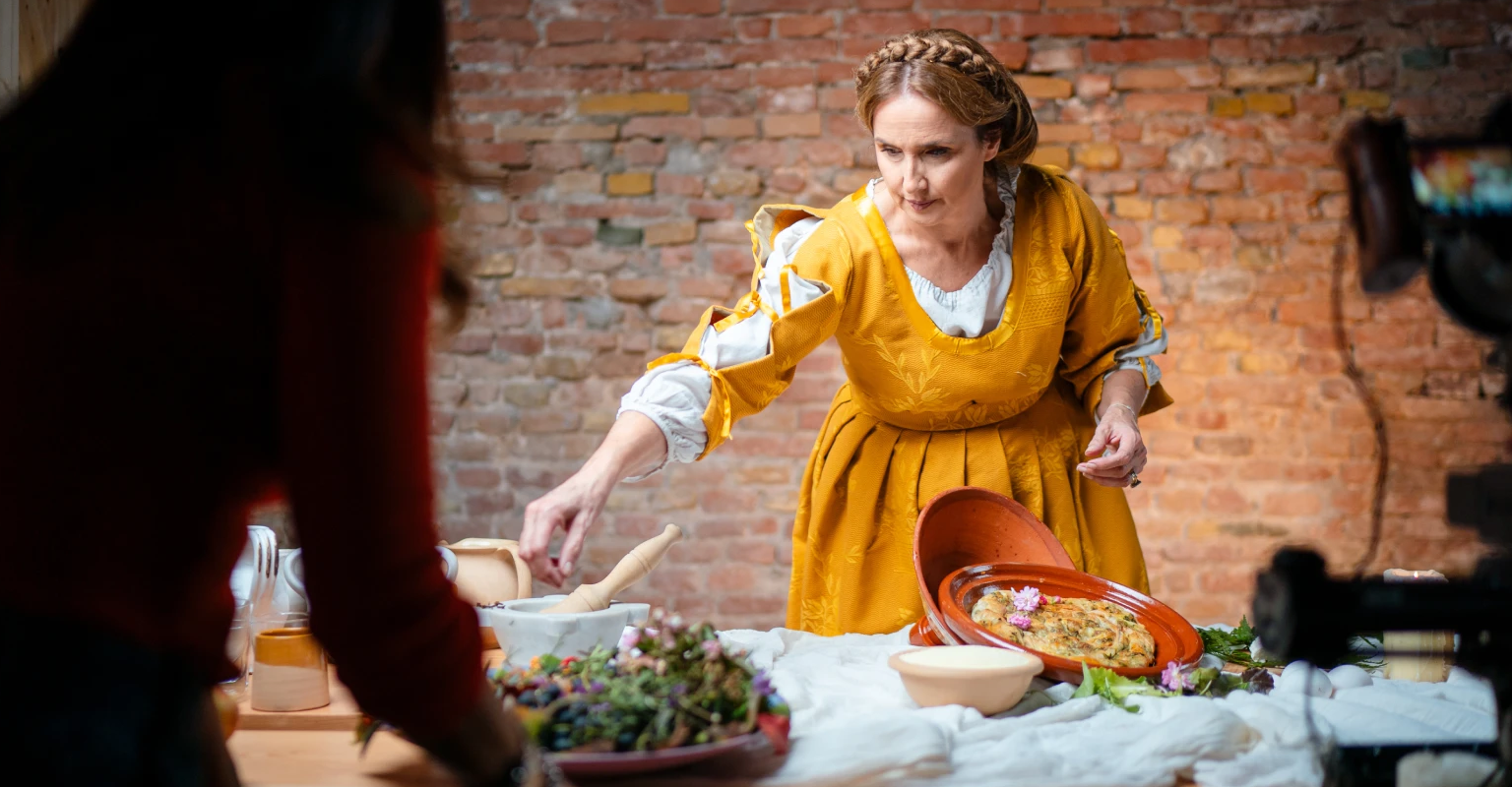 La ricostruzione delle pietanze nasce da una ricerca dedicata alla cucina storica, trasformando fonti e ricette in elementi reali dell’esperienza.
