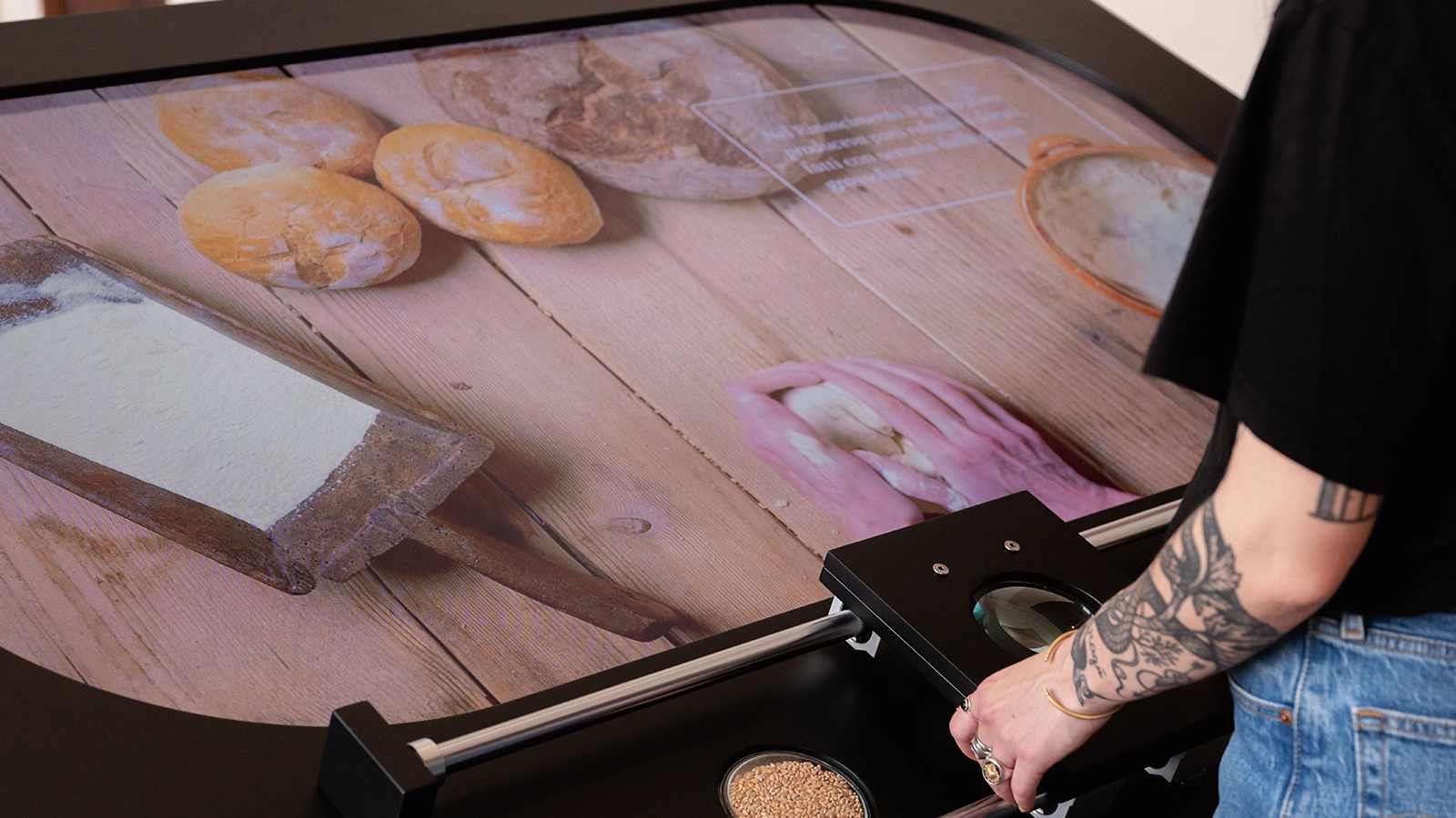L’interazione con gli elementi presenti sul tavolo attiva contenuti audiovisivi dedicati alla cultura e alla lavorazione del pane.